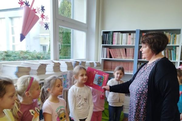 Pani Halina Hołowienko pasuje uczennicę na czytelnika