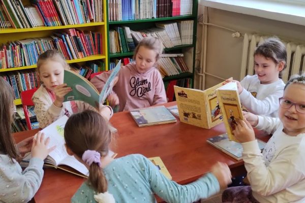 Uczennice przy stoliku prezentują otrzymane książki