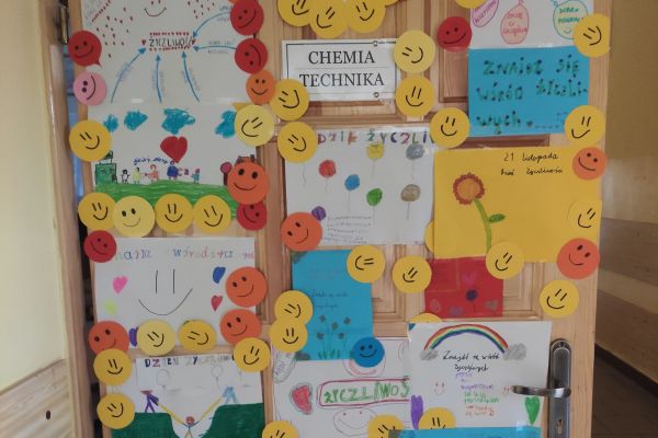 Kolorowo ozdobione drzwi klasy plakatami o życzliwości