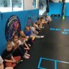 Dzieci_siedza_na_macie_i_czekaj_na_zajecia_sportowe